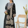 Woman wearing an elegant black embroidered long dress with beige and pink floral detailing, styled with gold clutch and pink heels