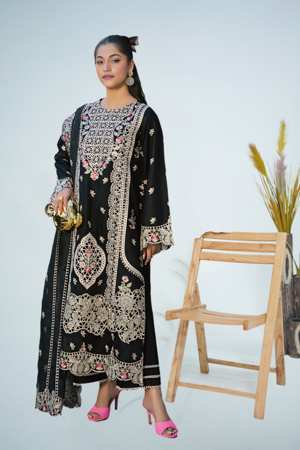 Woman wearing an elegant black embroidered long dress with beige and pink floral detailing, styled with gold clutch and pink heels