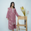 A model wearing Amzoclothing’s Dusty Mauve 3-piece cotton suit with boring embroidery, laser cutwork sleeves, cutwork trousers, and embroidered chiffon dupatta – Eid festive wear 2025.