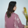 A model wearing Amzoclothing’s Dusty Mauve 3-piece cotton suit with boring embroidery, laser cutwork sleeves, cutwork trousers, and embroidered chiffon dupatta – Eid festive wear 2025.
