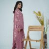 A model wearing Amzoclothing’s Dusty Mauve 3-piece cotton suit with boring embroidery, laser cutwork sleeves, cutwork trousers, and embroidered chiffon dupatta – Eid festive wear 2025.