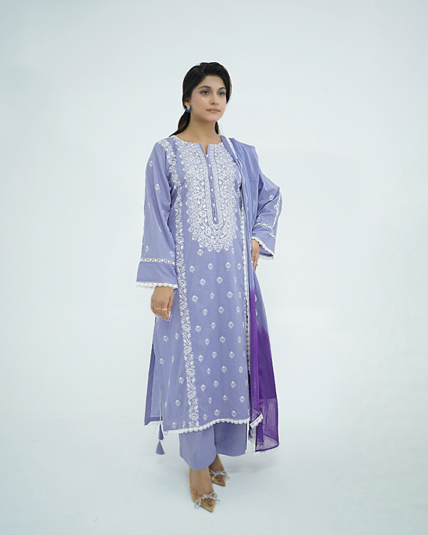 A model wearing Amzoclothing’s Cerulean Blue 3-piece embroidered lawn suit with white threadwork and ombre chiffon dupatta – Eid and summer festive wear 2025.