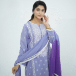 A model wearing Amzoclothing’s Cerulean Blue 3-piece embroidered lawn suit with white threadwork and ombre chiffon dupatta – Eid and summer festive wear 2025.