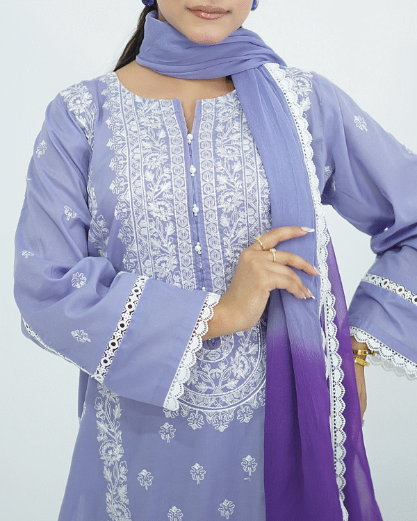 A model wearing Amzoclothing’s Cerulean Blue 3-piece embroidered lawn suit with white threadwork and ombre chiffon dupatta – Eid and summer festive wear 2025.
