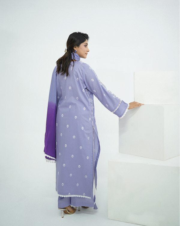 A model wearing Amzoclothing’s Cerulean Blue 3-piece embroidered lawn suit with white threadwork and ombre chiffon dupatta – Eid and summer festive wear 2025.