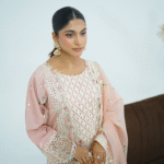 Model wearing Dessert rose pink embroidered cotton dress with cutwork neckline, organza sleeves, and heavy dupatta by Amzoclothing