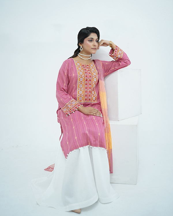 Model in pink embroidered lawn Eid dress with pearl details, white sharara pants, and printed net dupatta – Amzoclothing Eid 2025.