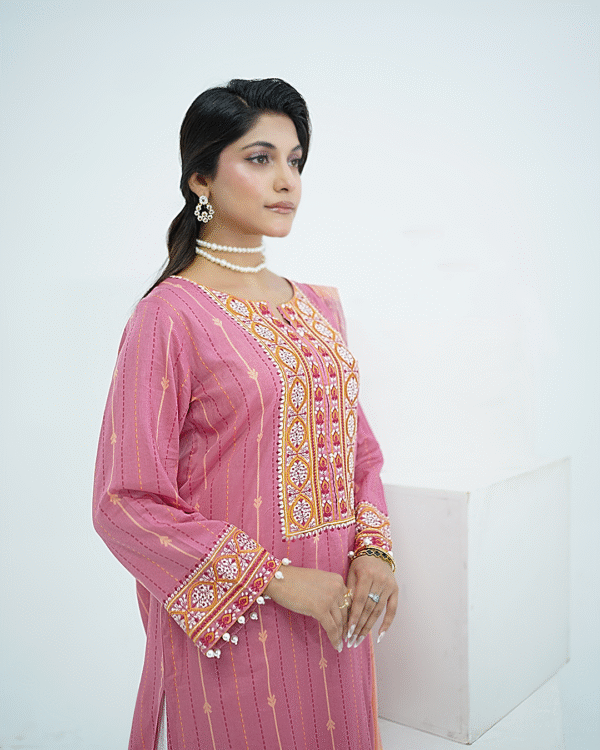 Model in pink embroidered lawn Eid dress with pearl details, white sharara pants, and printed net dupatta – Amzoclothing Eid 2025.