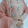 A model wearing a peach embroidered lawn Eid dress with intricate boring design and organza border, paired with a cotton net dupatta with embroidered borders – Amzoclothing festive collection.