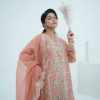 A model wearing a peach embroidered lawn Eid dress with intricate boring design and organza border, paired with a cotton net dupatta with embroidered borders – Amzoclothing festive collection.