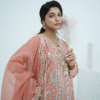 A model wearing a peach embroidered lawn Eid dress with intricate boring design and organza border, paired with a cotton net dupatta with embroidered borders – Amzoclothing festive collection.