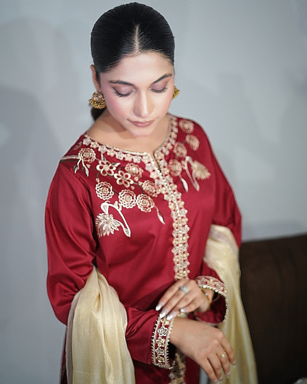 Girl wearing Maroon cotton satin embroidered dress with gold tilla and sequin detailing, paired with masuri gold dupatta featuring traditional tassels – Festive wear from Amzoclothing Eid collection 2025